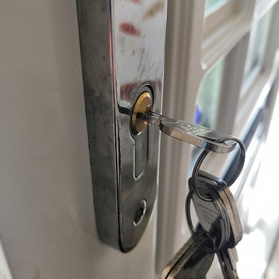 Professional locksmith replacing a front door lock to enhance home security, advising new homeowners to change all locks when moving into a new property to ensure no previous keys provide access.