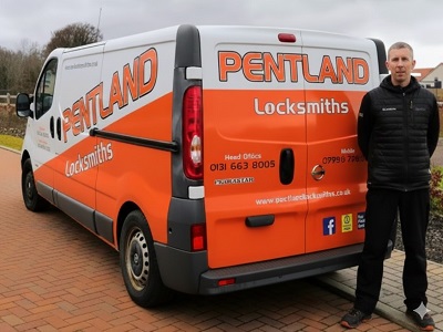 A photo of Chris from Pentland Locksmiths Services standing beside his branded locksmith van in Midlothian, displaying his professional local mobile and landline numbers.