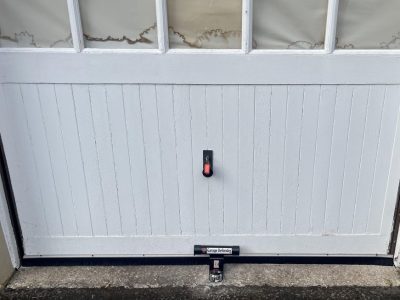 High-security garage door defender installed in front of an up-and-over garage door to prevent forced entry and enhance garage security.